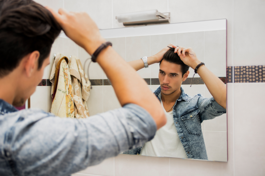 Reflection of Man Bushing Hair in Mirror