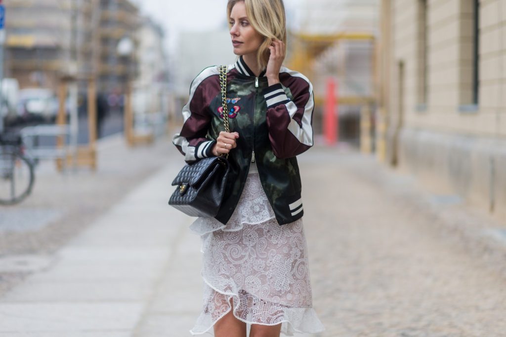 BERLIN, GERMANY - JANUARY 20: Lisa Hahnbueck wearing Velention Satin Bomber Jacket with Butterfly Patches, Self-Portrait Lace Skirt with Frilles, Chanel Timeless Flap Bag, VANS Sk8-Hi during the Mercedes-Benz Fashion Week Berlin A/W 2017 at Kaufhaus Jandorf on January 20, 2017 in Berlin, Germany. (Photo by Christian Vierig/Getty Images)